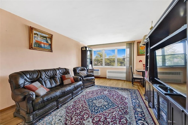 living room featuring light wood-type flooring, baseboards, and radiator