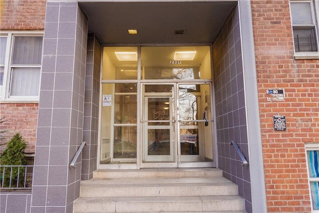 doorway to property featuring brick siding