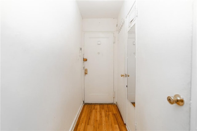 hallway featuring baseboards and light wood finished floors