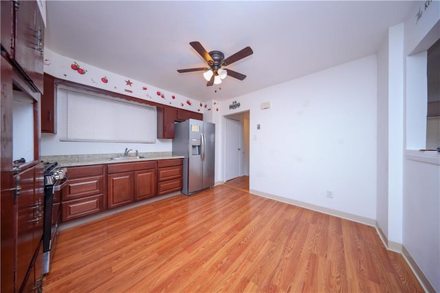 kitchen featuring sink, light wood-type flooring, ceiling fan, and appliances with stainless steel finishes