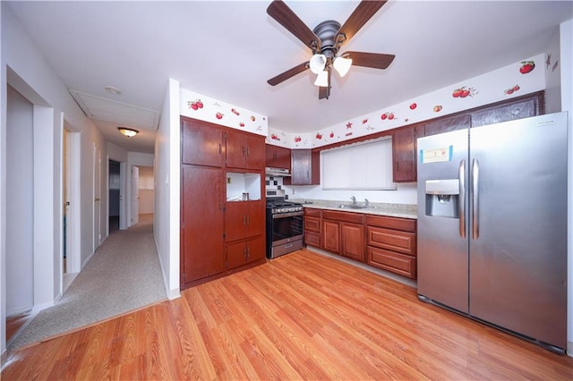 kitchen featuring ceiling fan, stainless steel appliances, sink, and light hardwood / wood-style flooring