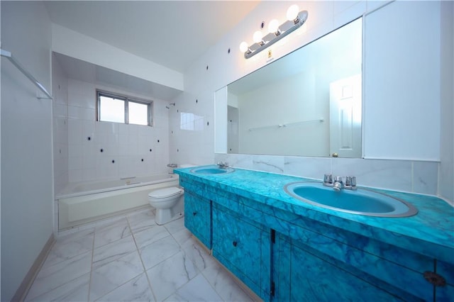 full bathroom with tiled shower / bath, vanity, and toilet