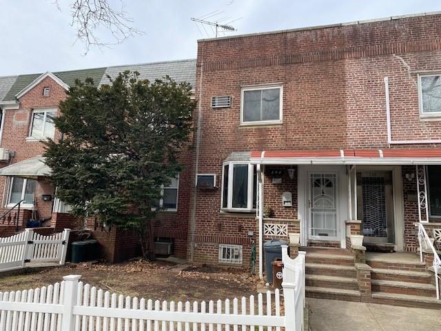 view of property with a fenced front yard and brick siding