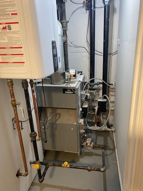 utility room featuring tankless water heater