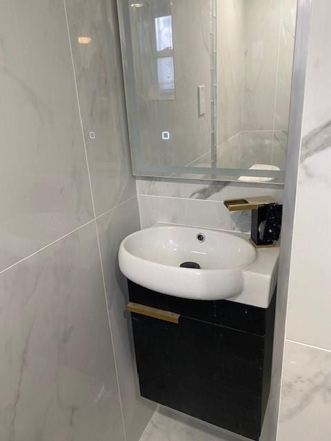 298 Bay 14th St, Brooklyn, NY 11214 - bathroom with vanity and tile walls