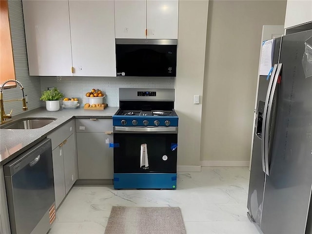 kitchen featuring appliances with stainless steel finishes, marble finish floor, a sink, and gray cabinets