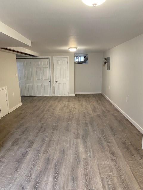 finished below grade area with dark wood-style flooring and baseboards