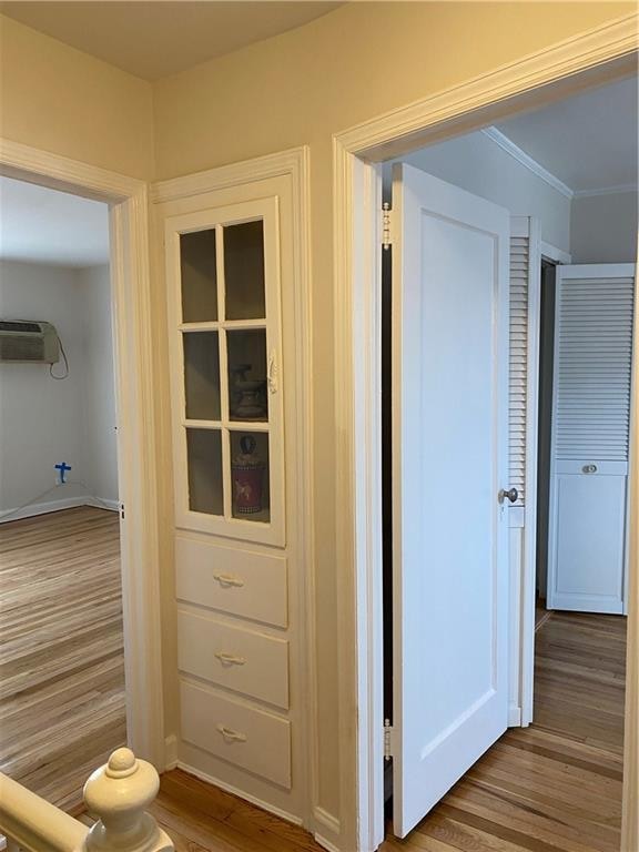 298 Bay 14th St, Brooklyn, NY 11214 - hall with wood finished floors, a wall unit AC, ornamental molding, and baseboards