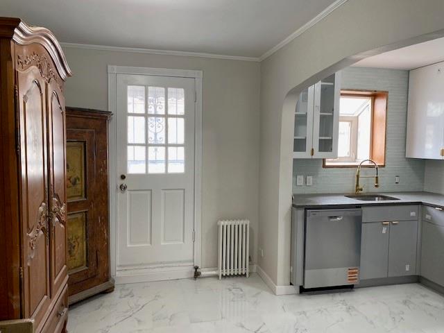 298 Bay 14th St, Brooklyn, NY 11214 - doorway to outside with a sink, radiator, light marble finish flooring, crown molding, and arched walkways