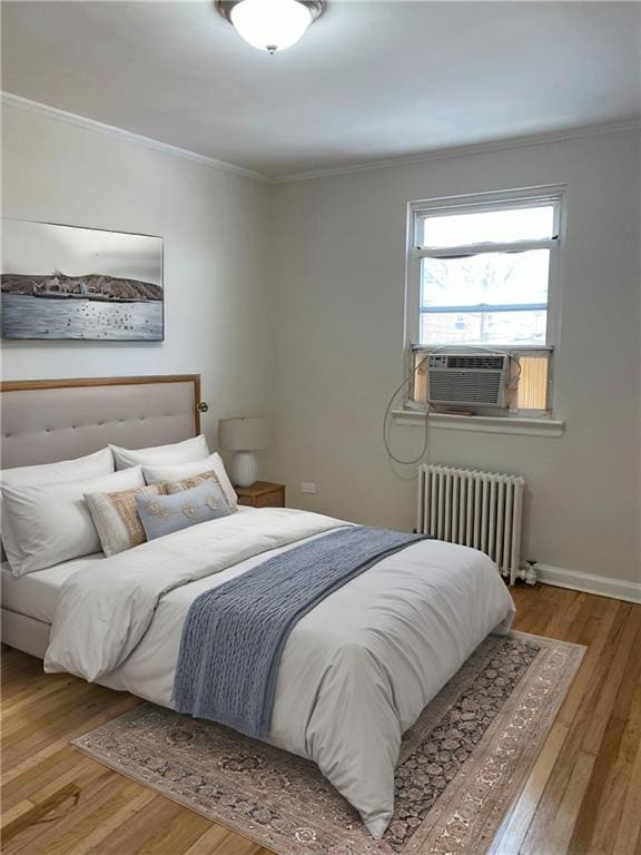 298 Bay 14th St, Brooklyn, NY 11214 - bedroom featuring radiator heating unit, wood finished floors, and ornamental molding