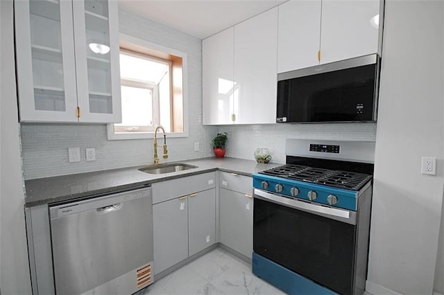 298 Bay 14th St, Brooklyn, NY 11214 - kitchen with appliances with stainless steel finishes, white cabinetry, light marble finish flooring, and decorative backsplash