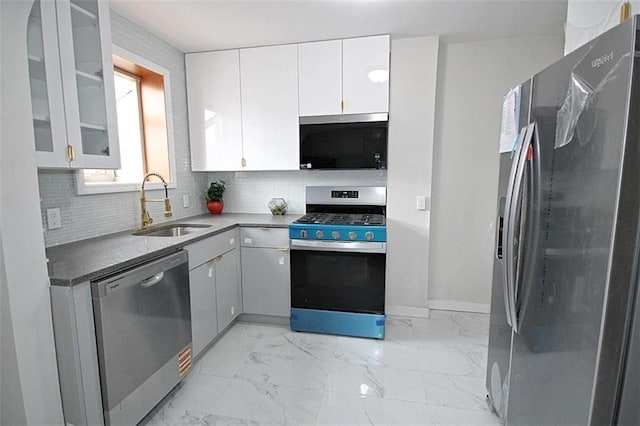 298 Bay 14th St, Brooklyn, NY 11214 - kitchen featuring appliances with stainless steel finishes, white cabinetry, decorative backsplash, and light marble finish flooring