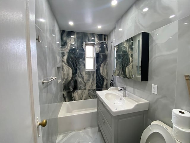 full bathroom with toilet, shower / tub combination, marble finish floor, vanity, and tile walls