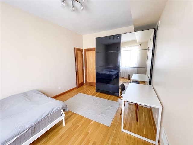 bedroom featuring baseboards and light wood finished floors