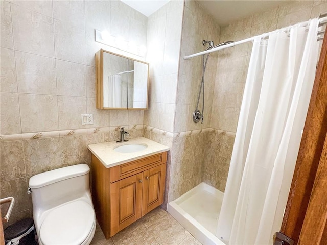 full bath with a stall shower, vanity, toilet, and tile walls