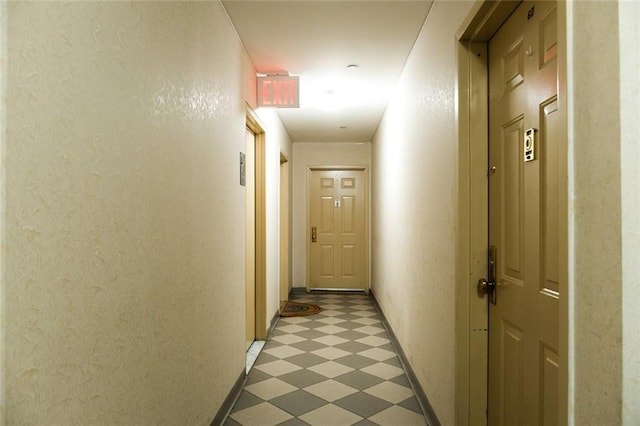 hall with dark floors and baseboards