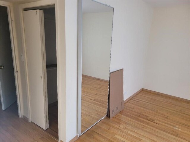 hallway with light hardwood / wood-style floors