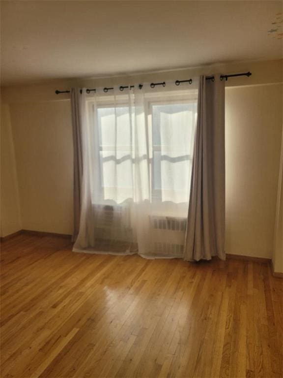 2935 W 5th St Unit 16E, Brooklyn, NY 11224 - unfurnished room featuring radiator heating unit and wood finished floors