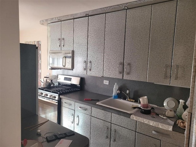 2935 W 5th St Unit 16E, Brooklyn, NY 11224 - kitchen with appliances with stainless steel finishes, a sink, and dark countertops