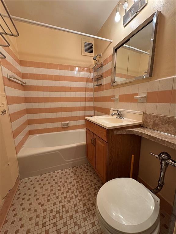 bathroom featuring tile walls, visible vents, bathing tub / shower combination, and vanity