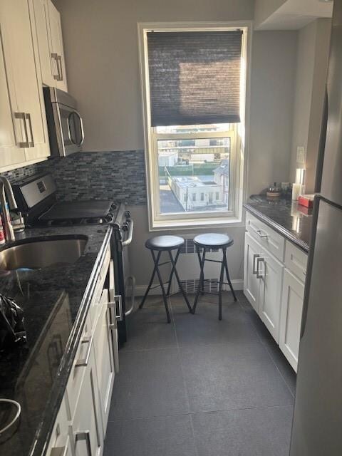 kitchen featuring tasteful backsplash, appliances with stainless steel finishes, sink, and white cabinets