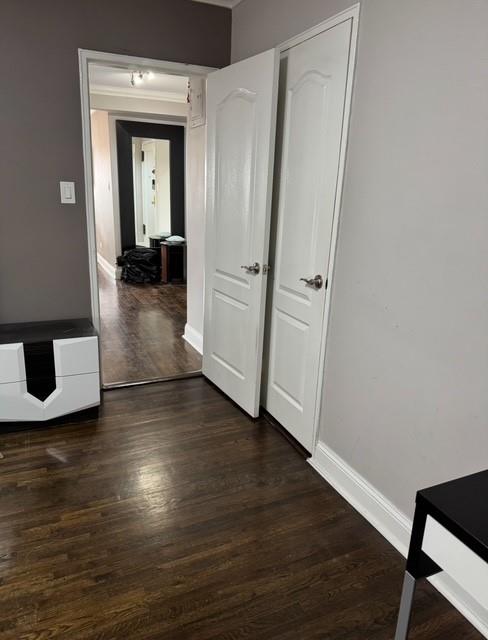 hallway with baseboards and dark wood-style flooring