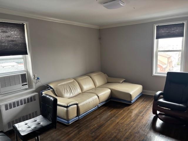 living area featuring radiator, cooling unit, baseboards, dark wood finished floors, and ornamental molding