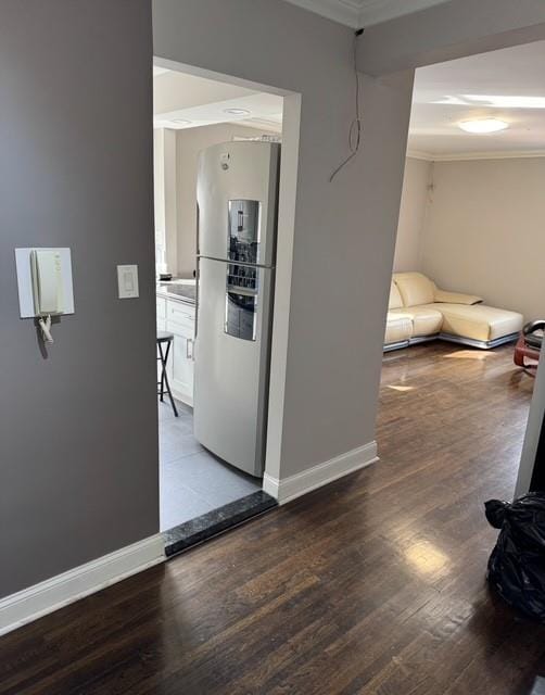 hallway featuring wood finished floors, baseboards, and ornamental molding