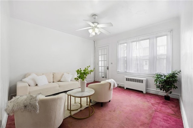 living area with a ceiling fan, radiator, carpet flooring, and baseboards