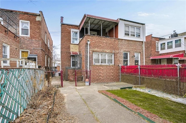 back of house with brick siding and a fenced backyard