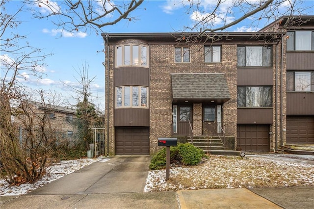 view of front of house featuring concrete driveway, brick siding, and a garage