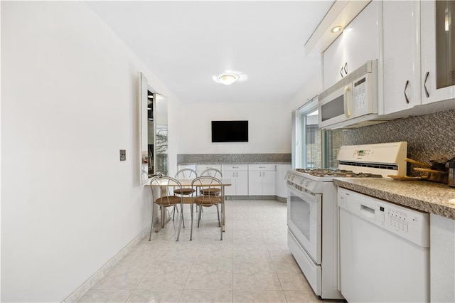 kitchen featuring backsplash, baseboards, white cabinetry, and white appliances