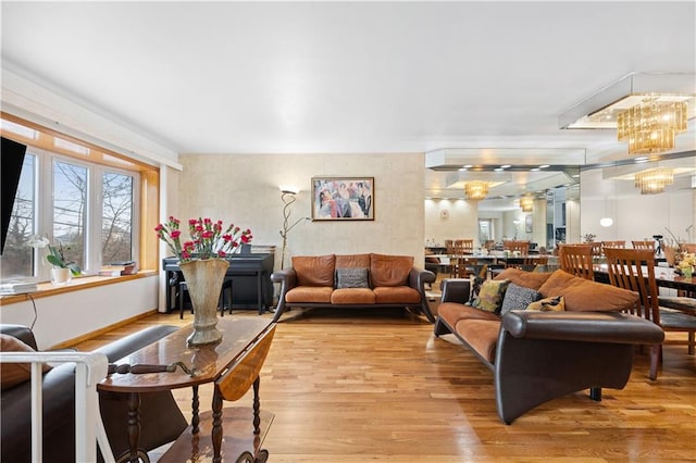 living area with light wood-type flooring and a notable chandelier