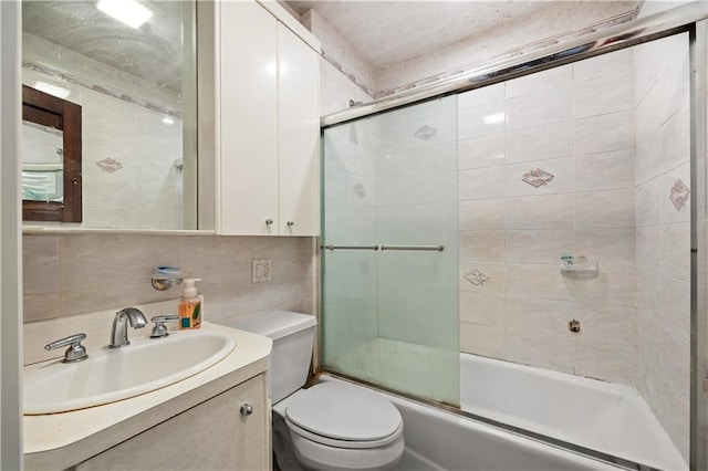 full bathroom featuring toilet, tasteful backsplash, shower / bath combination with glass door, tile walls, and vanity