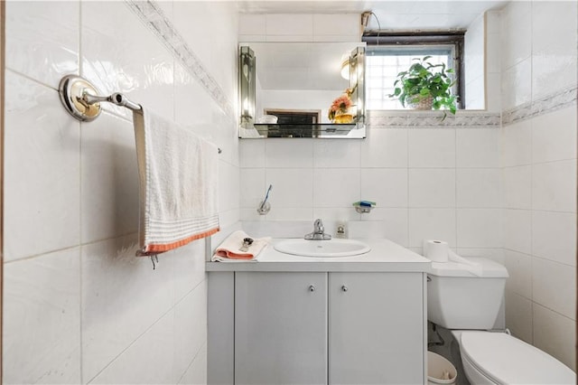 bathroom featuring tile walls, vanity, and toilet