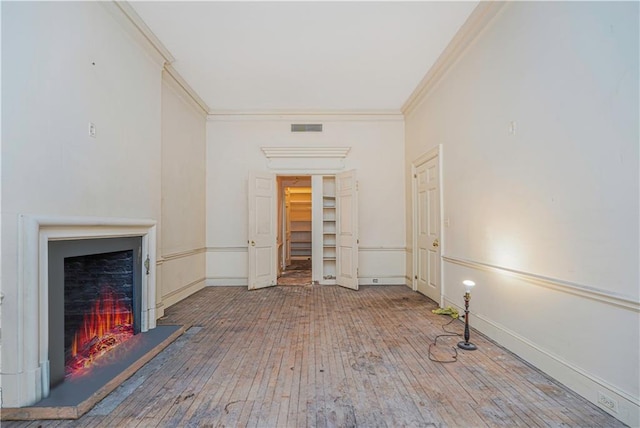 unfurnished living room with hardwood / wood-style flooring and ornamental molding