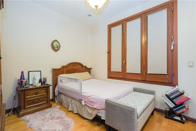 bedroom featuring light wood-style floors and baseboards