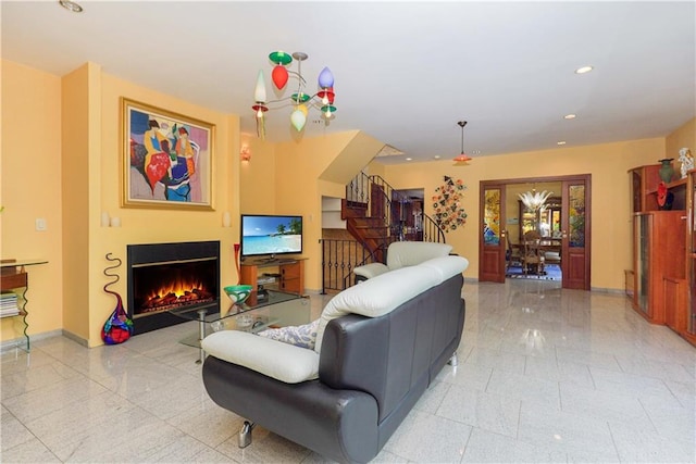 living room with a warm lit fireplace, granite finish floor, baseboards, and recessed lighting