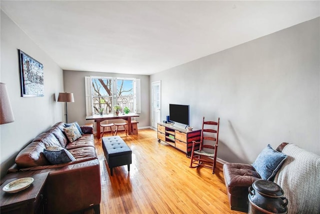 living area with baseboards and light wood finished floors