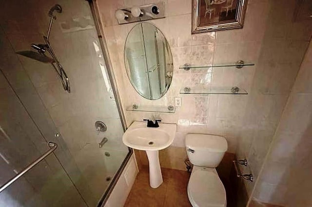 bathroom featuring shower / bath combination, tile walls, and toilet