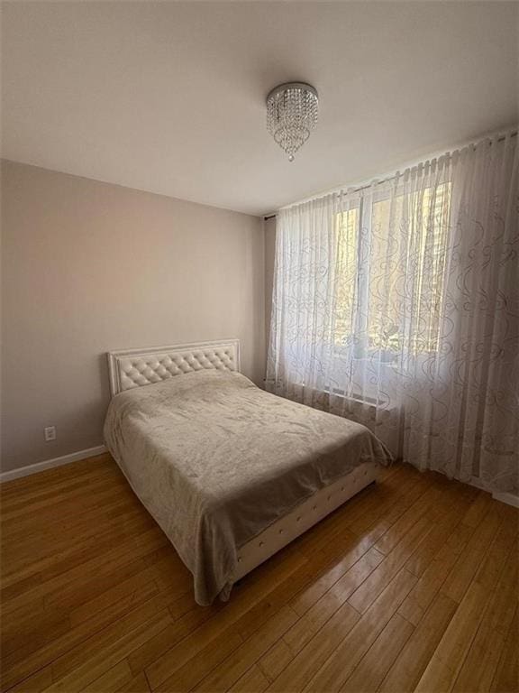 bedroom featuring wood-type flooring and baseboards