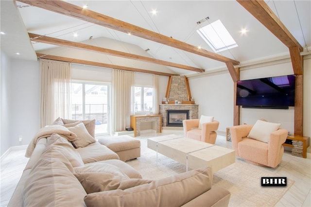 living area featuring baseboards, a stone fireplace, and lofted ceiling with skylight