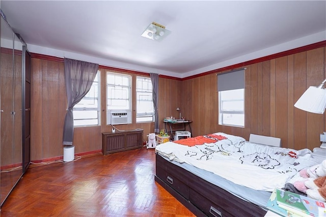 bedroom with radiator, dark parquet flooring, and wooden walls