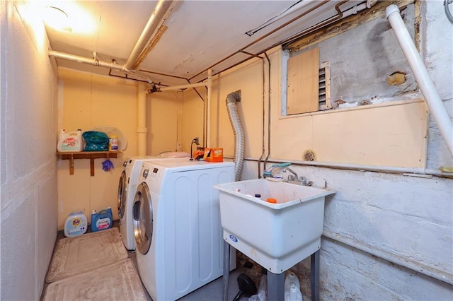 clothes washing area with sink and independent washer and dryer