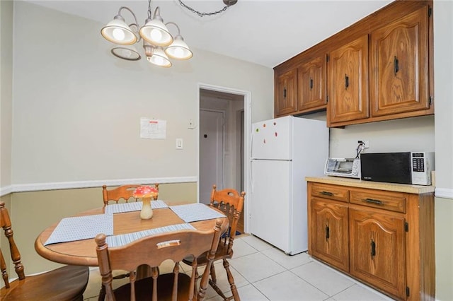 dining area with light tile patterned floors and a chandelier