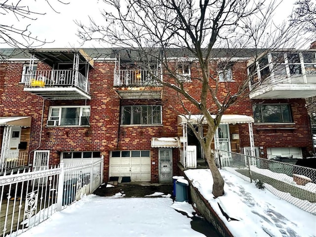 townhome / multi-family property featuring brick siding, an attached garage, fence, and cooling unit