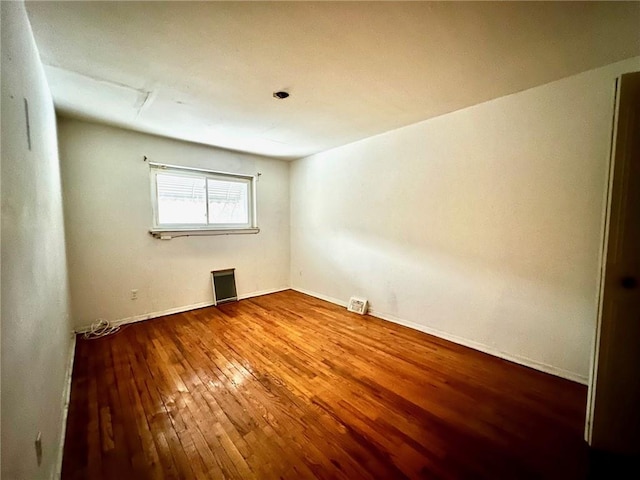 unfurnished room with wood-type flooring and visible vents