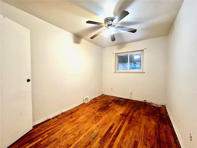 spare room featuring visible vents, ceiling fan, baseboards, and wood finished floors