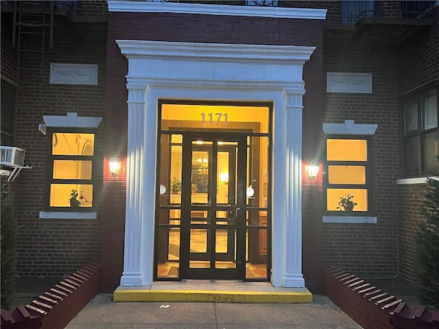 property entrance featuring brick siding and french doors