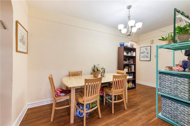 dining room with baseboards, wood finished floors, and an inviting chandelier
